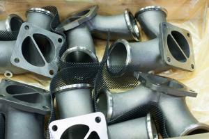 Verpackung von Abgaskrümmern für Großdieselmotoren aus SiMo mit Schutznetz.